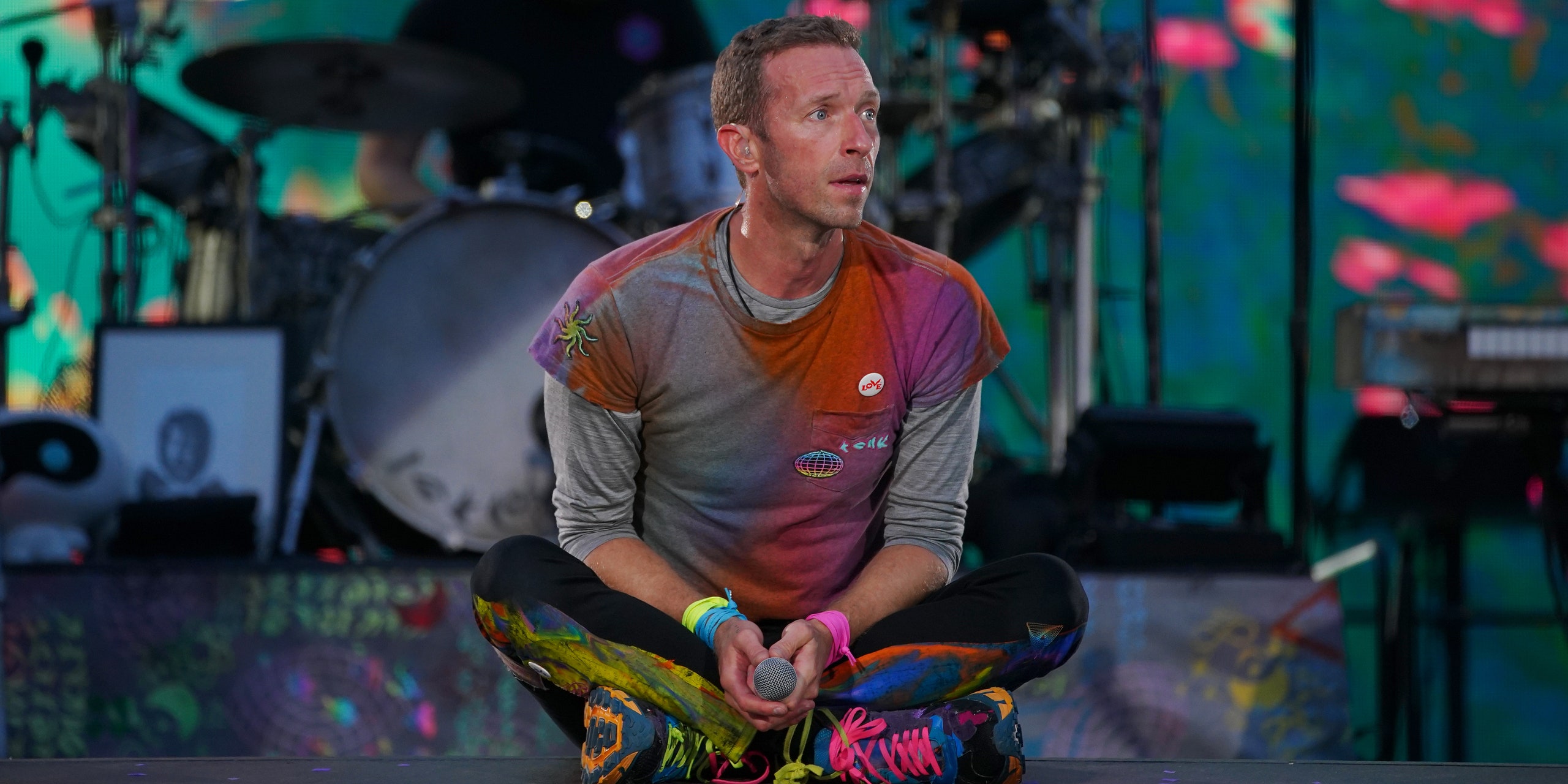 Coldplays Chris Martin sitting crosslegged